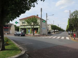 Pharmacie de la Vieille Poste, Paray-Vieille-Poste. Photographie de la pharmacie depuis l’îlot central de la place Henri Barbusse (crédits : Maison de banlieue et de l’Architecture, Manon Bélec, photographe)